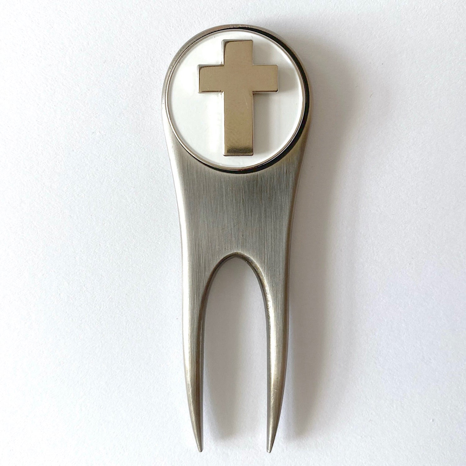 A silver golf divot tool with a magnetic ball marker featuring the U.S. Army Chaplain Corps Cross insignia.