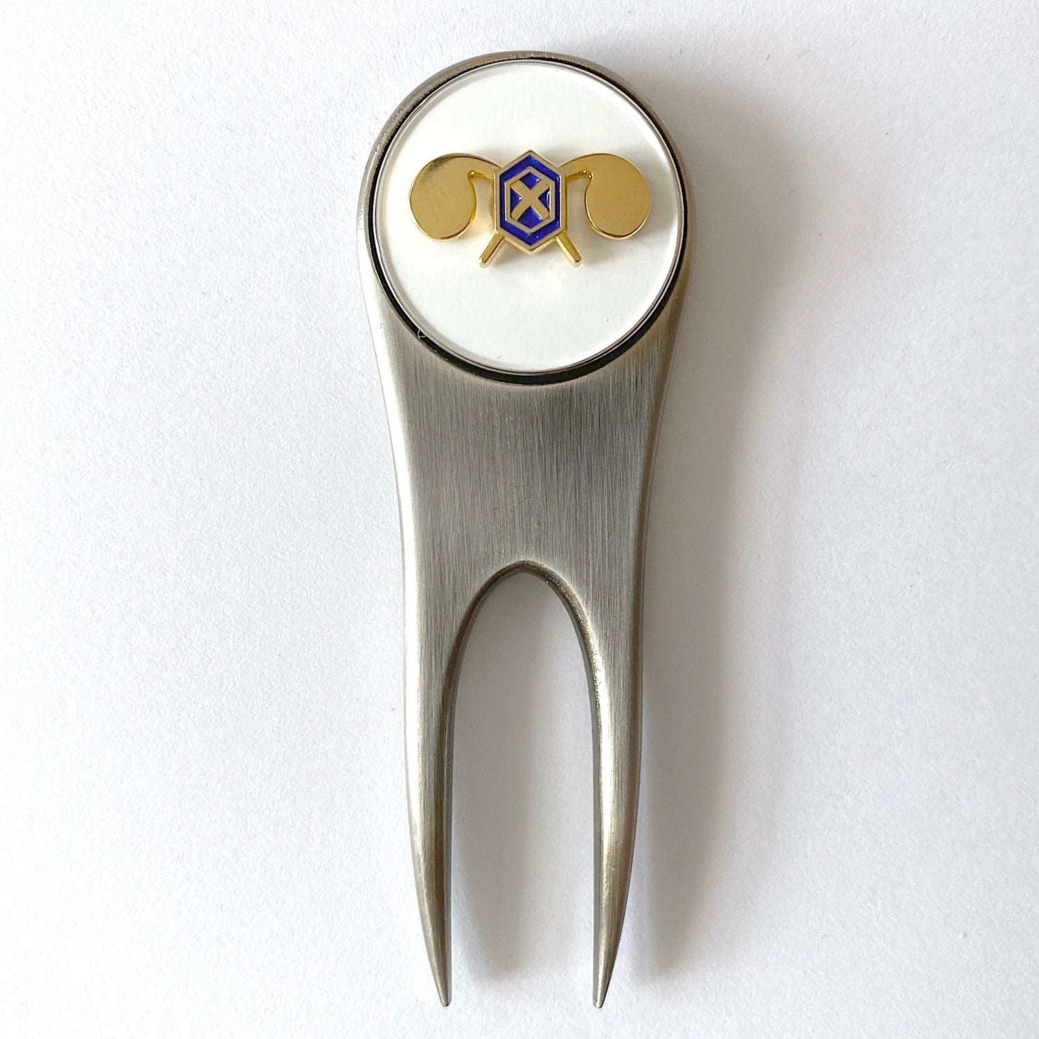 A silver golf divot tool with a magnetic ball marker featuring the U.S. Army Chemical Corps insignia centerpiece.