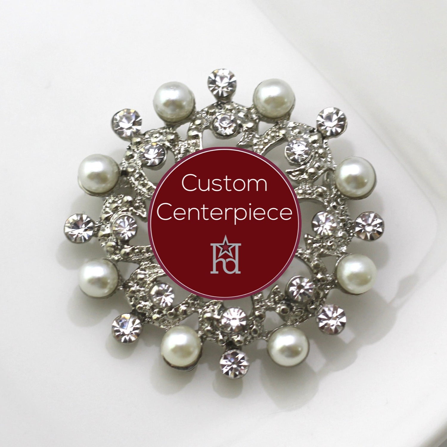 A silver brooch with faux pearls and clear crystals designed for custom centerpieces.