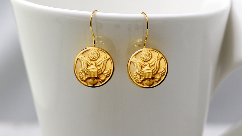 Gold Army Button French Wire Earrings on a white cup