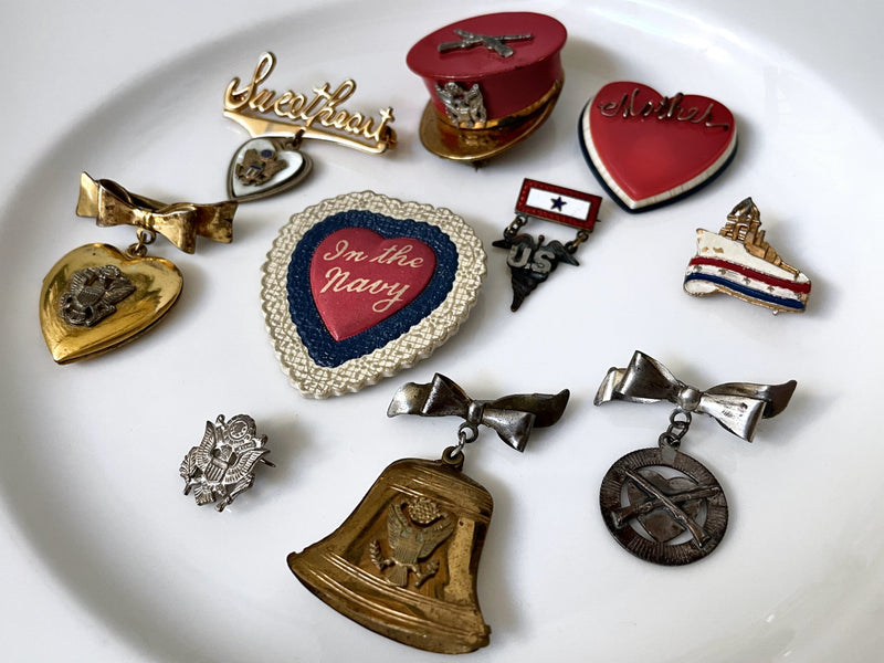 Collection of vintage pins on a white plate