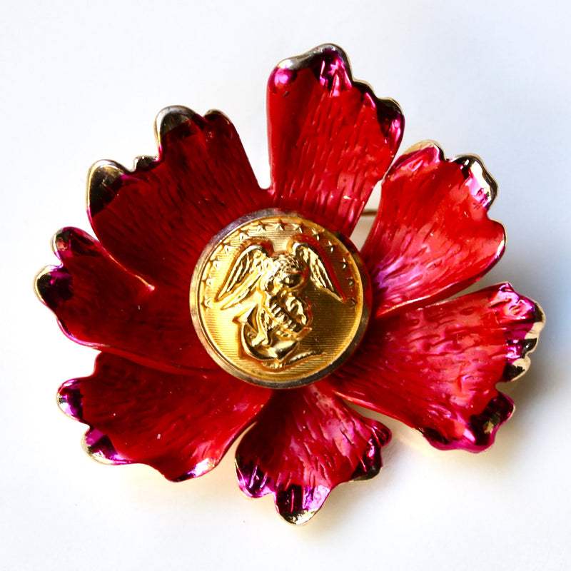 Red floral brooch with gold Marine Corps button centerpiece on white background