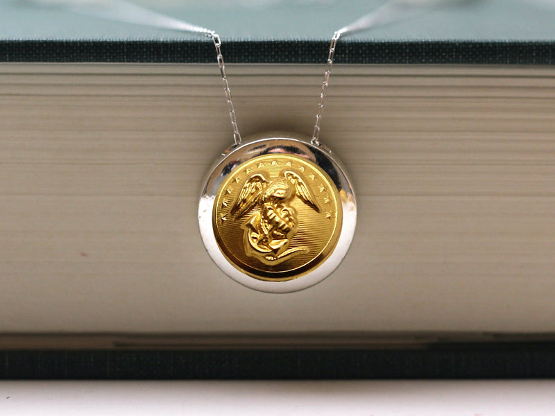 Marine button silver french wire earrings on a white cup