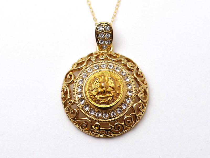 Gold and crystal charm with Navy button center with a gold chain on a white background