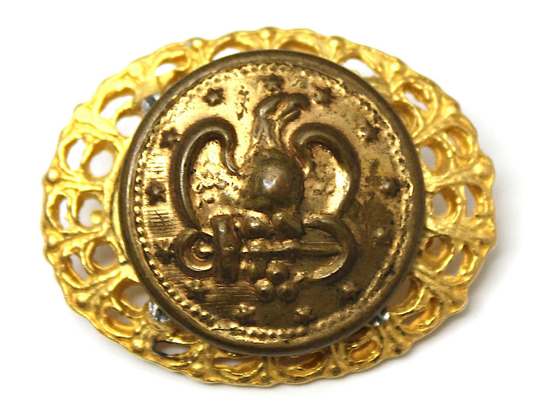 Vintage gold brooch with a Navy button on a white background