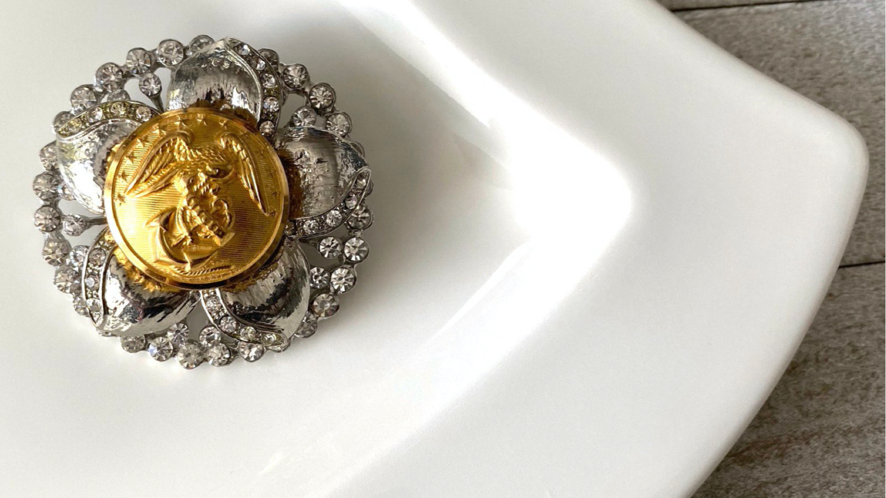 Gold coin with silver decorative frame on a white dish