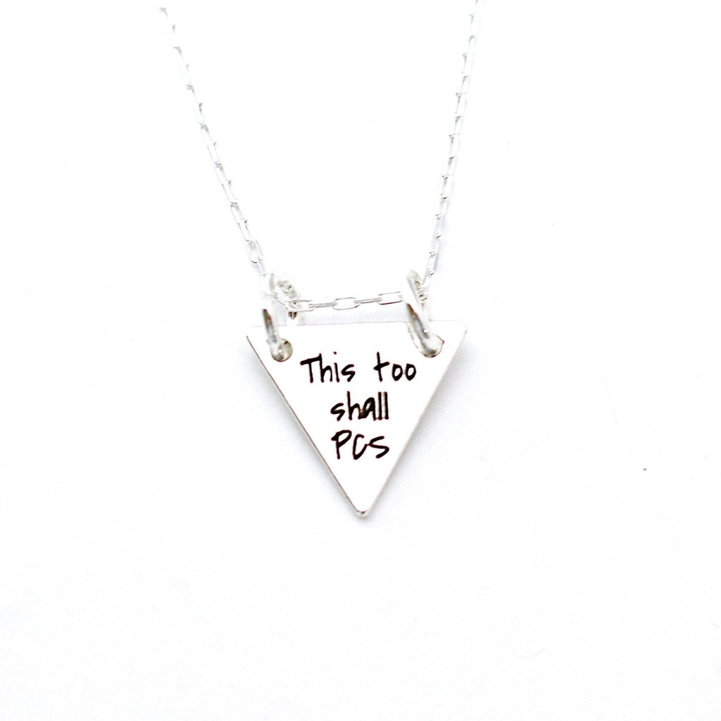 Silver necklace with a triangular pendant on a white background