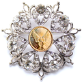 Decorative brooch with crystal-like stones and a gold center on a white background