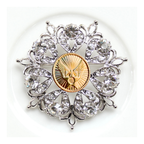 Decorative brooch with crystal elements and a gold center on a white background