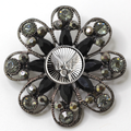 Decorative brooch with black gemstones and silver Air Force inspired centerpiece on a white background