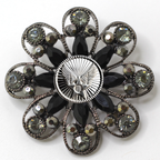 Decorative brooch with black gemstones and silver Air Force inspired centerpiece on a white background