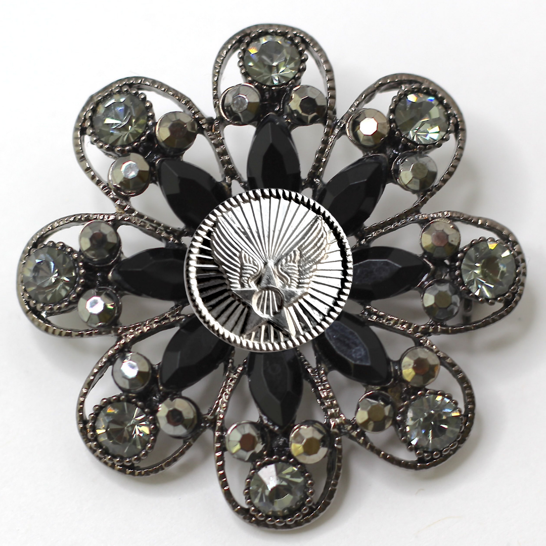 Decorative brooch with black gemstones and silver Air Force inspired centerpiece on a white background