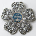 Decorative brooch with 'Air Force' emblem and crystal-like stones on a white background