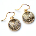 Gold earrings with eagle design on a white background