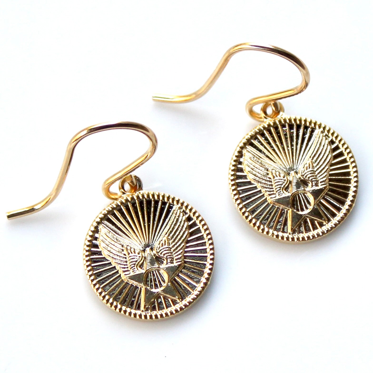 Gold earrings with eagle design on a white background