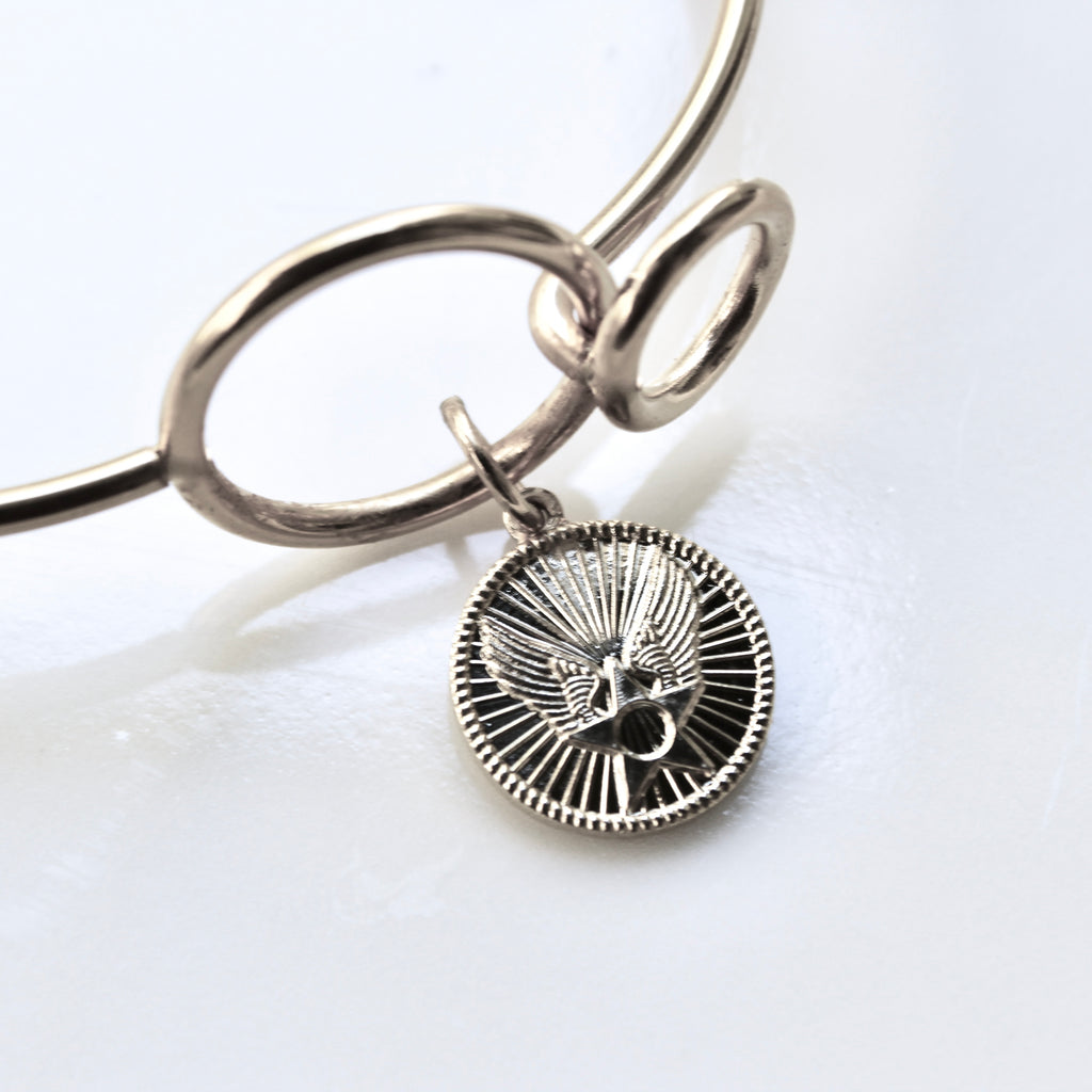 Silver bracelet with a round pendant on a white background