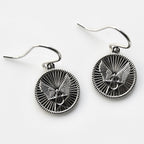 Silver eagle head earrings on a white background