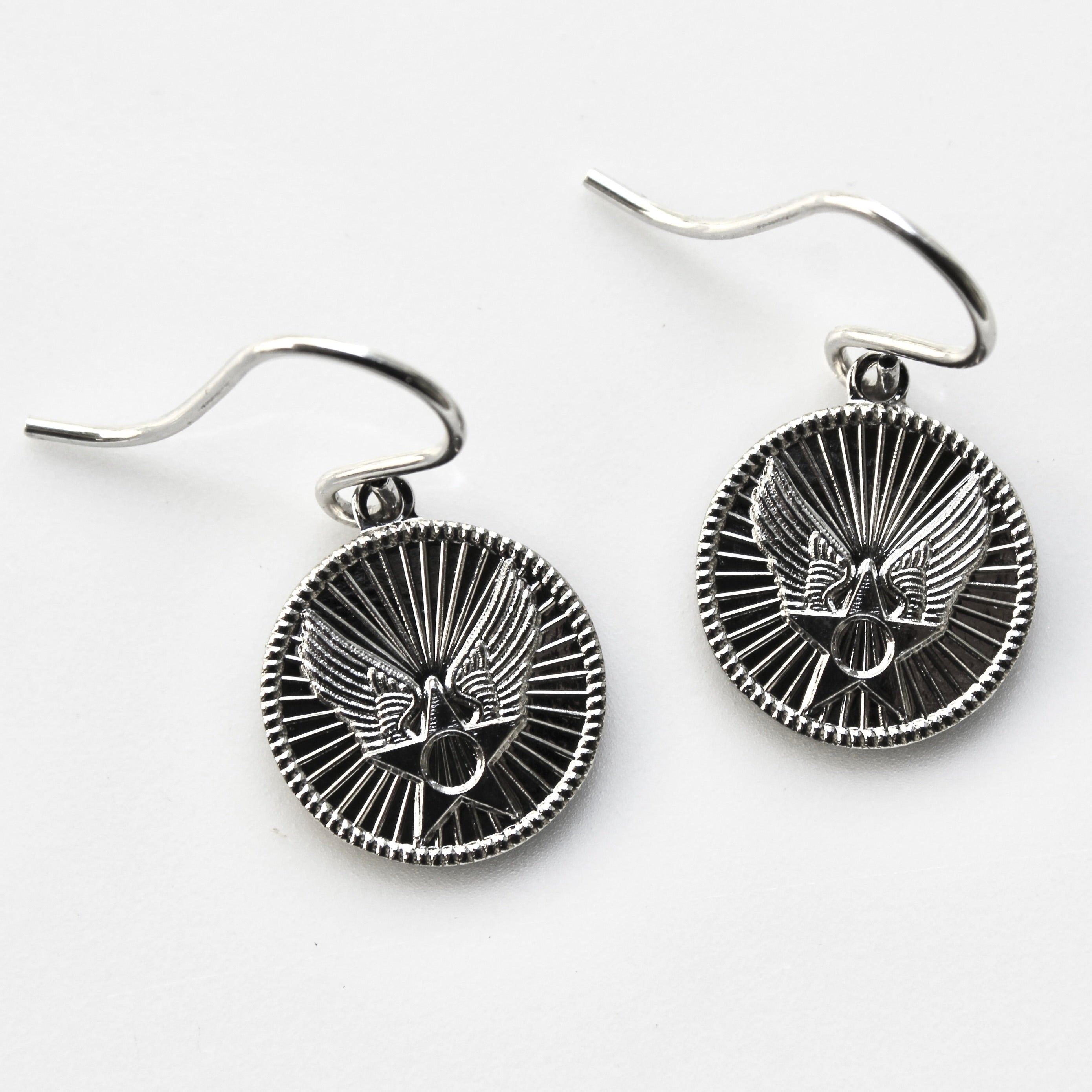 Silver eagle head earrings on a white background