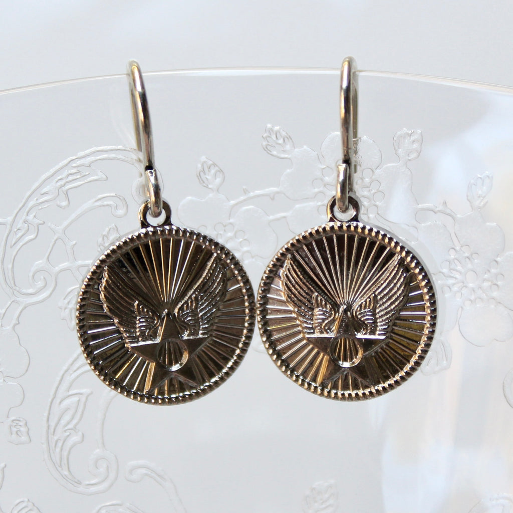 Pair of round earrings with intricate design on a white background