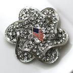 Silver four-leaf clover charm with American flag on a white background