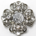 Decorative brooch with crystal-like stones on a white background
