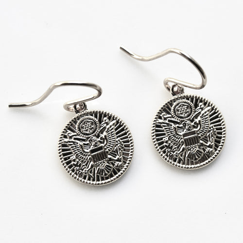Pair of silver earrings with intricate designs on a white background