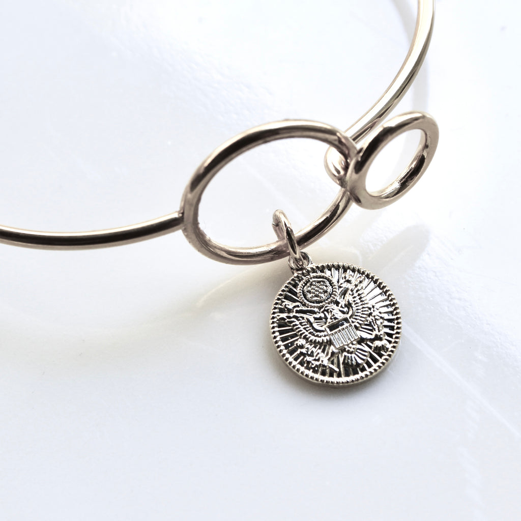Silver bracelet with a detailed pendant on a white background