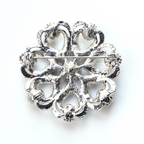 Decorative silver brooch on a white background