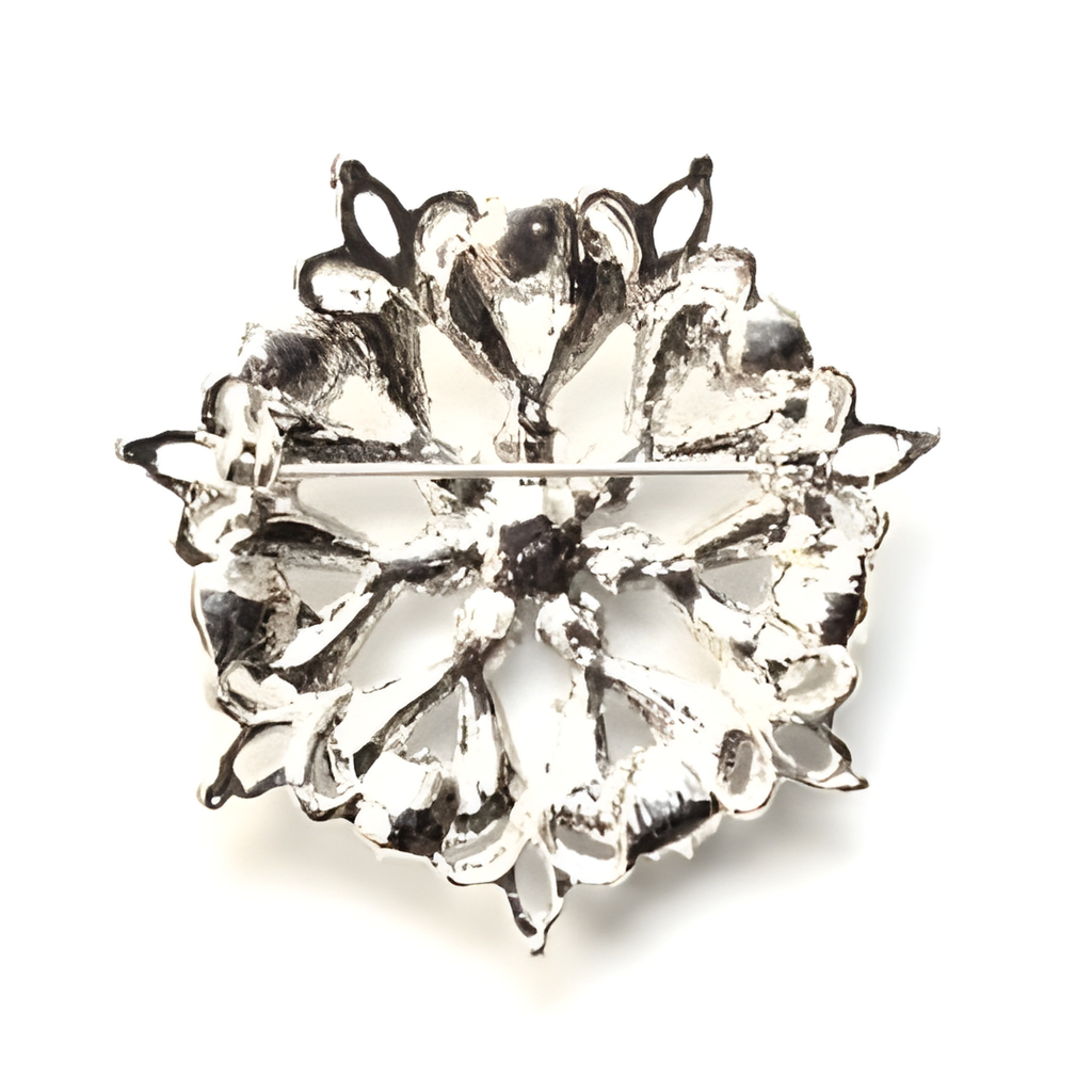 Silver brooch with a floral design on a white background