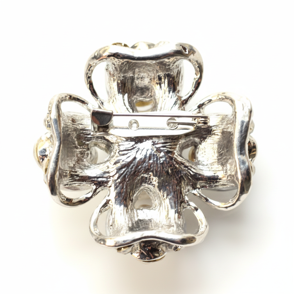 Silver four-leaf clover brooch on a white background