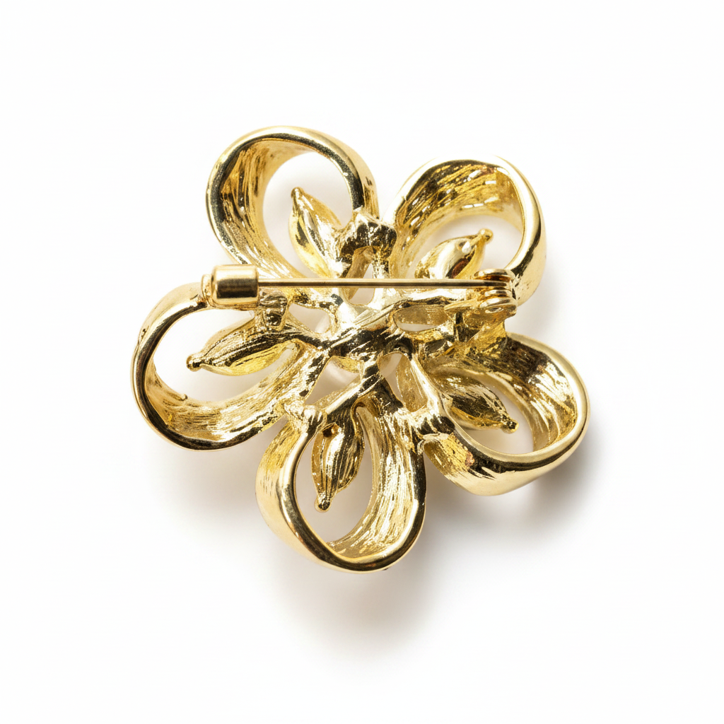 Gold four-leaf clover brooch on a white background