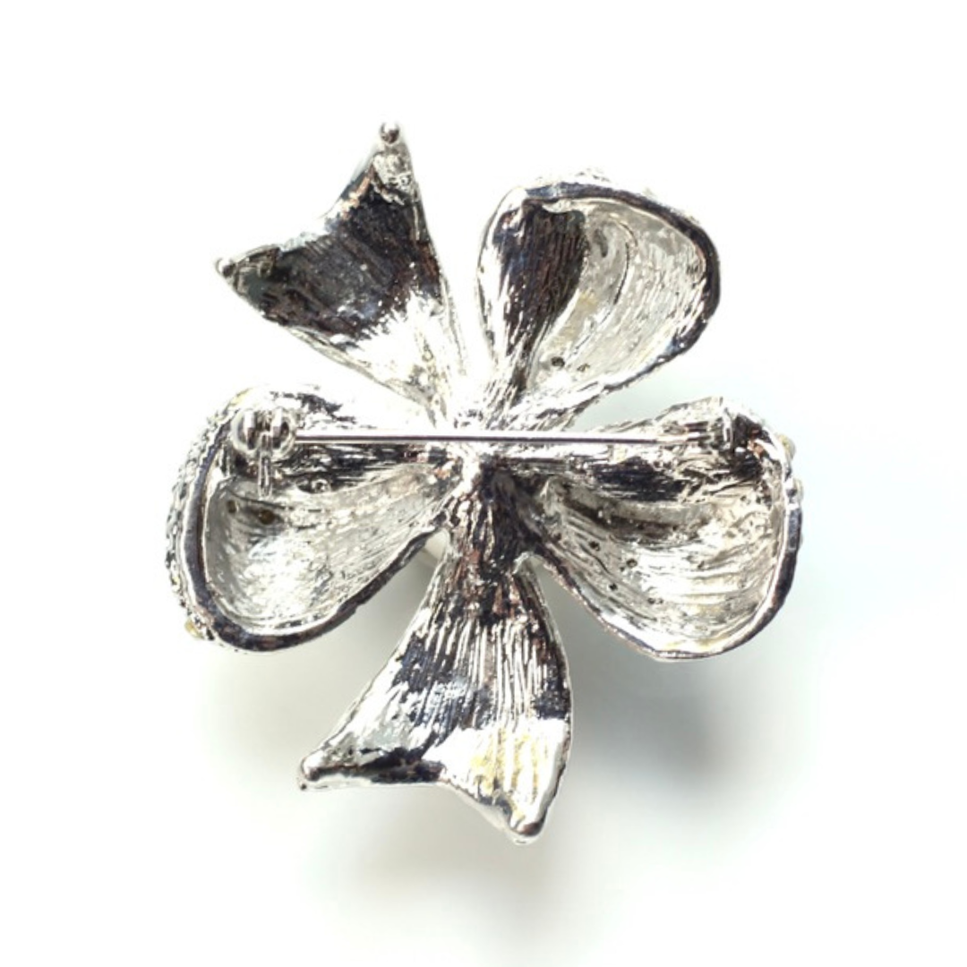 Silver four-leaf clover charm on a white background