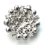 Silver brooch with intricate design on a white background