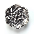 Silver brooch with intricate design on a white background