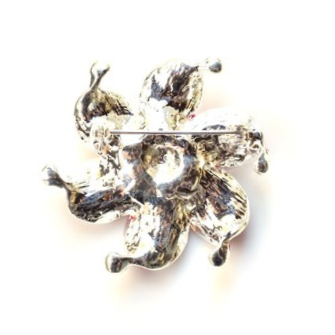 Silver brooch with a design on a white background