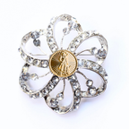 Decorative brooch with crystal-like stones and a gold National Guard center on a white background