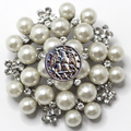 Brooch with pearls and a central emblem on a white background