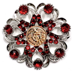 Decorative brooch with red gemstones and a gold Coast Guard center on a white background