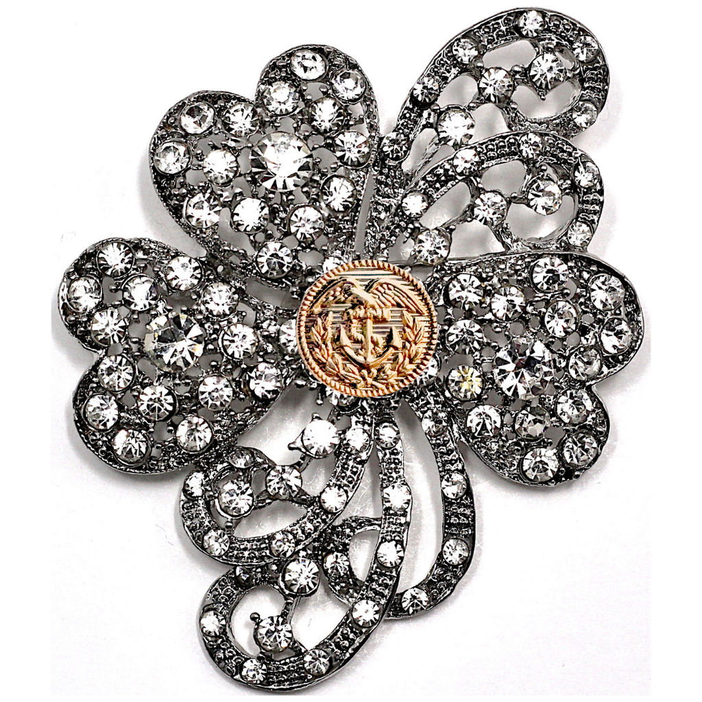 Decorative brooch with floral design and gold center on a white background