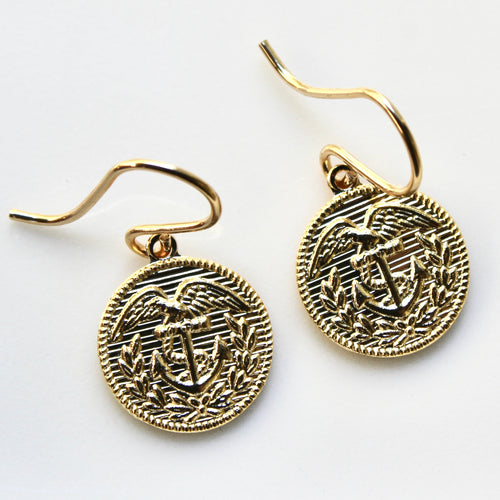 Gold earrings with anchor design on a white background