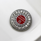 Round decorative item with crystals and red center on a white background