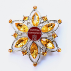 Decorative centerpiece with yellow gemstones and a red label on a white background