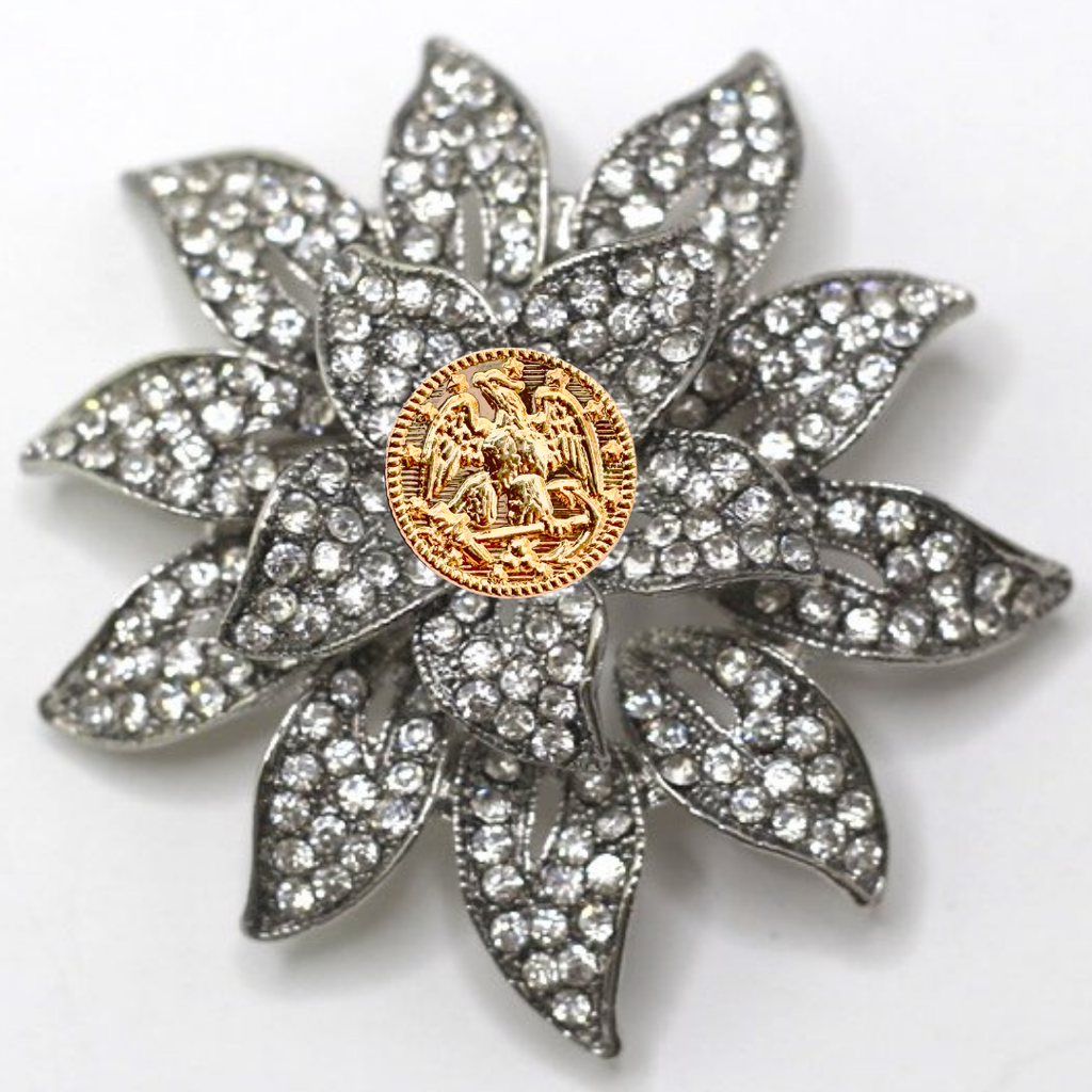 Decorative brooch with floral design and gold center on a white background