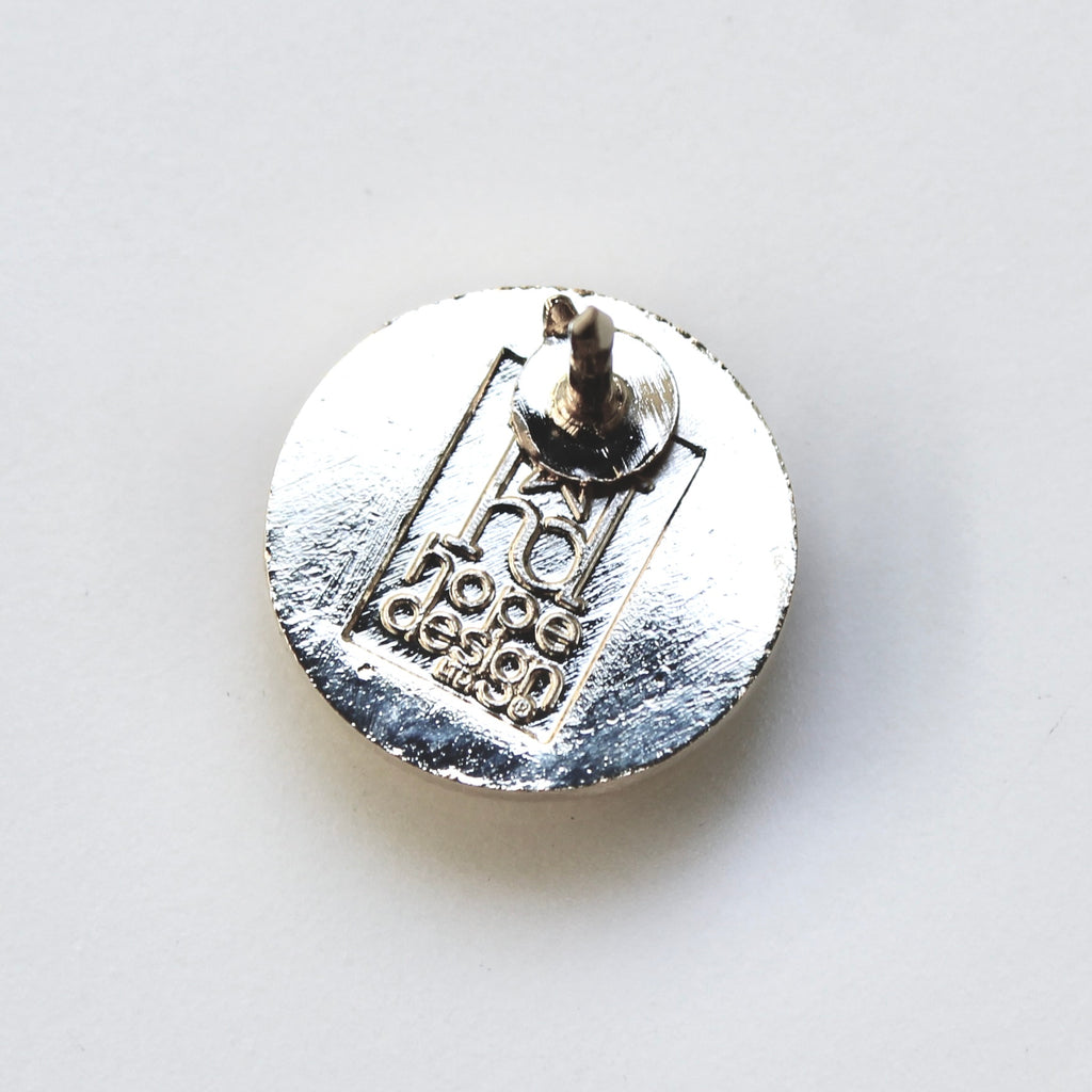 Silver badge with 'no hope design' text on a white background