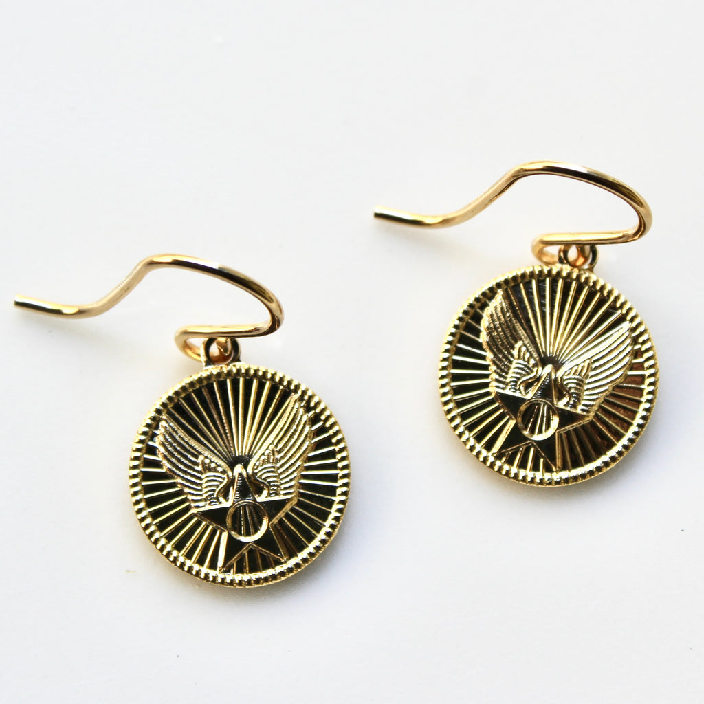 Gold earrings with an eagle design on a white background