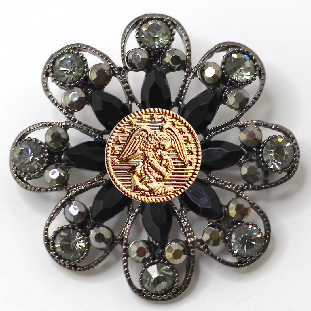 Decorative brooch with center Marines inspired gold center emblem and gemstone accents on a white background