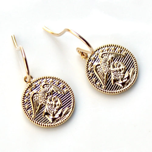 Gold coin-shaped earrings with a lion design on a white background