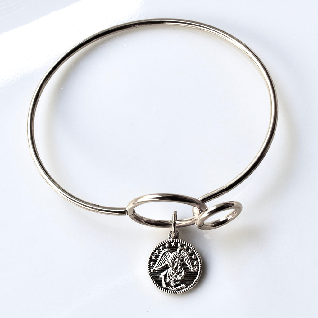 Silver bangle with a pendant on a white background