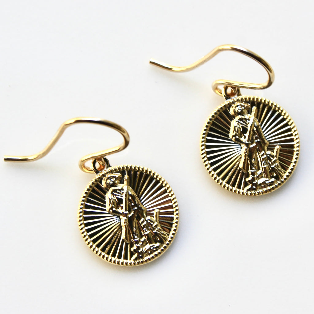 Gold earrings with intricate designs on a white background