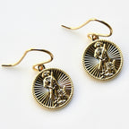 Gold earrings with intricate designs on a white background